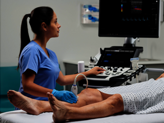 A female doctor is performing a vascular ultrasound exam