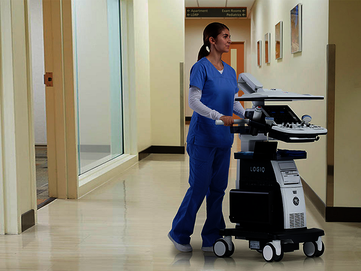 Eine Ärztin schiebt ein LOGIQ P10 XDclear Ultraschallsystem durch einen Krankenhausflur