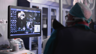 Ein Arzt in OP-Kleidung arbeitet an seinem Ultraschallgerät
