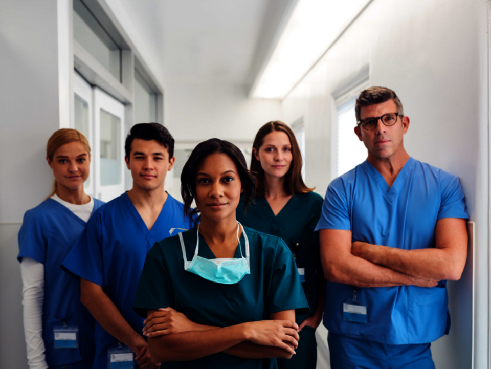 Group of doctors with folded arms looking into the camera