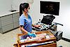 Na zdjęciu widać lekarza przeprowadzającego badanie ultrasonograficzne wątroby u dziecka.