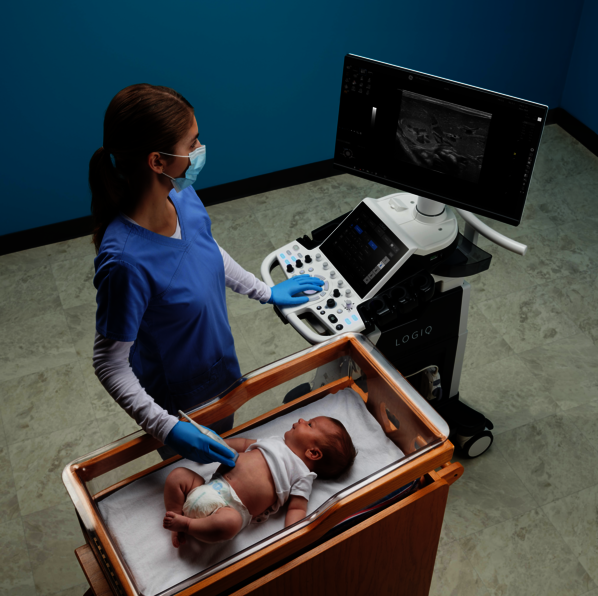 Das Bild zeigt einen Arzt, der bei einem Baby eine Ultraschalluntersuchung durchführt.