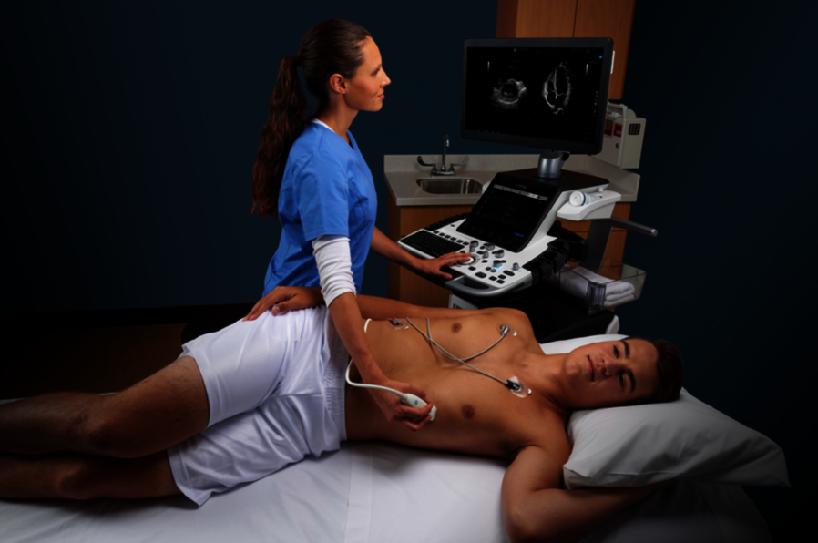 A female doctor performing a cardiac ultrasound exam on a male patient