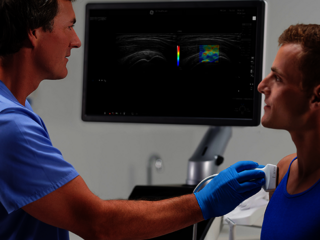 Ein Arzt führt eine Ultraschalluntersuchung an der Schulter eines Patienten durch