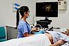 Obrázek znázorňuje lékaře provádějícího břišní ultrazvukové vyšetření u pacienta.