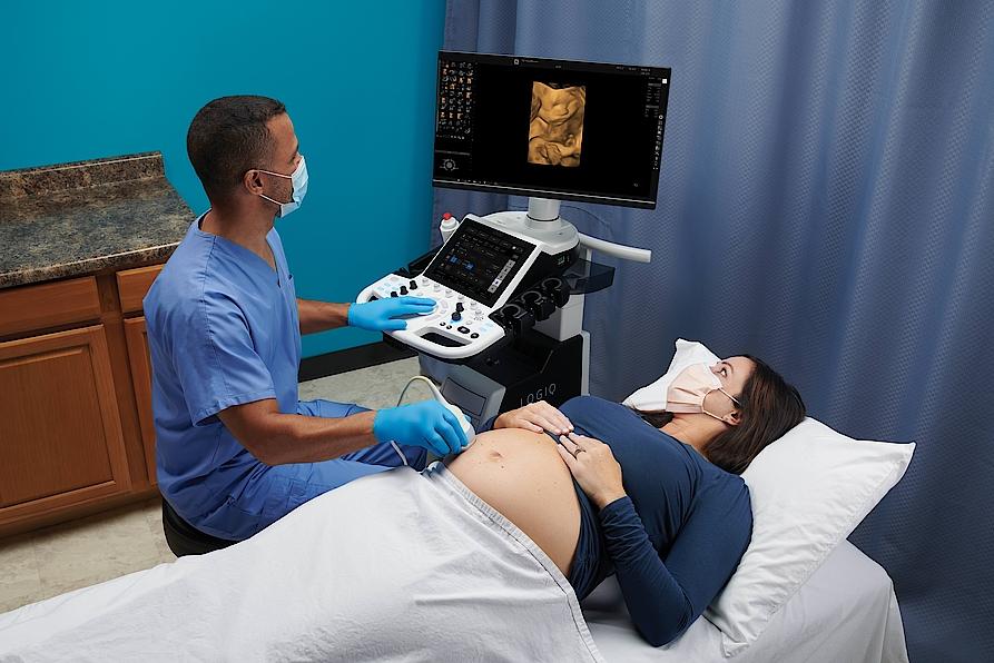 The picture shows a doctor performing an ultrasound examination on a pregnant woman.