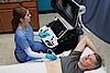 Η εικόνα δείχνει έναν ιατρό που εκτελεί υπερηχογραφική εξέταση κοιλίας σε έναν ασθενή.