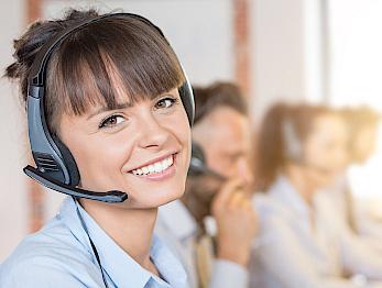 A woman with a headset is looking into the camera