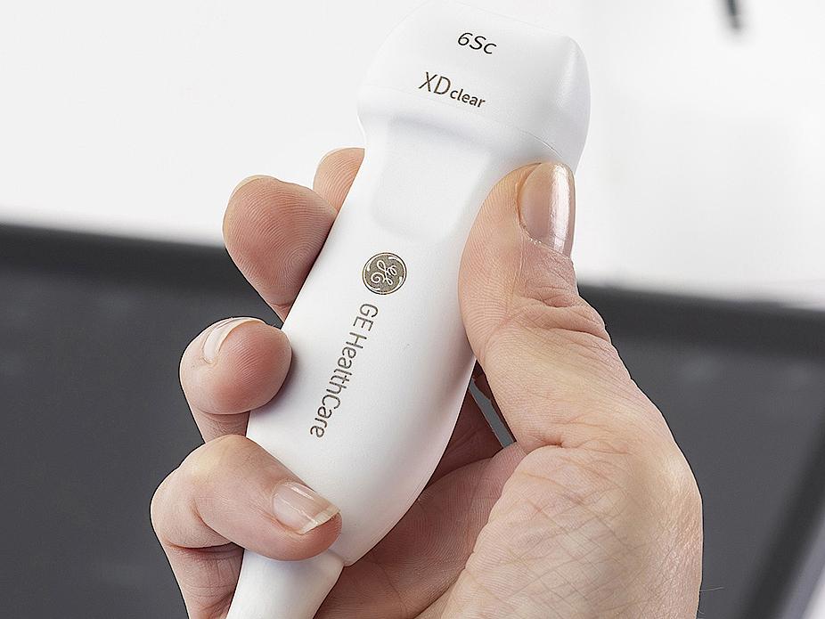 A person's hand holding an ultrasound probe