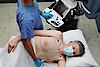 Das Bild zeigt einen Arzt, der bei einem Patienten eine kardiale Ultraschalluntersuchung durchführt.