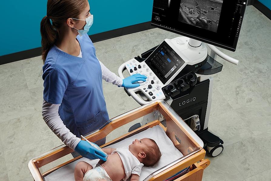 Das Bild zeigt einen Arzt, der bei einem Baby eine Ultraschalluntersuchung durchführt.