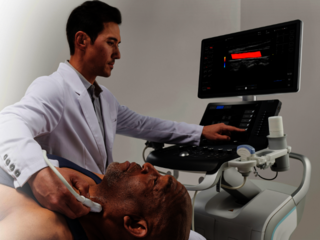 Ein Arzt führt eine Ultraschalluntersuchung der Schilddrüse durch