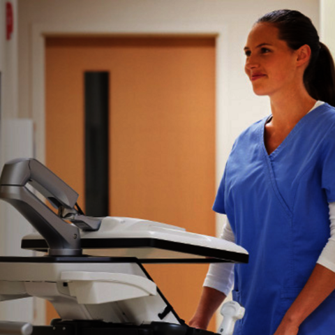 A nurse standing in front of an ultrasound system