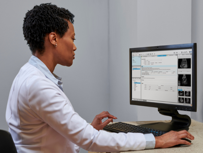 A physician is sitting at her desk using the ViewPoint 6 software